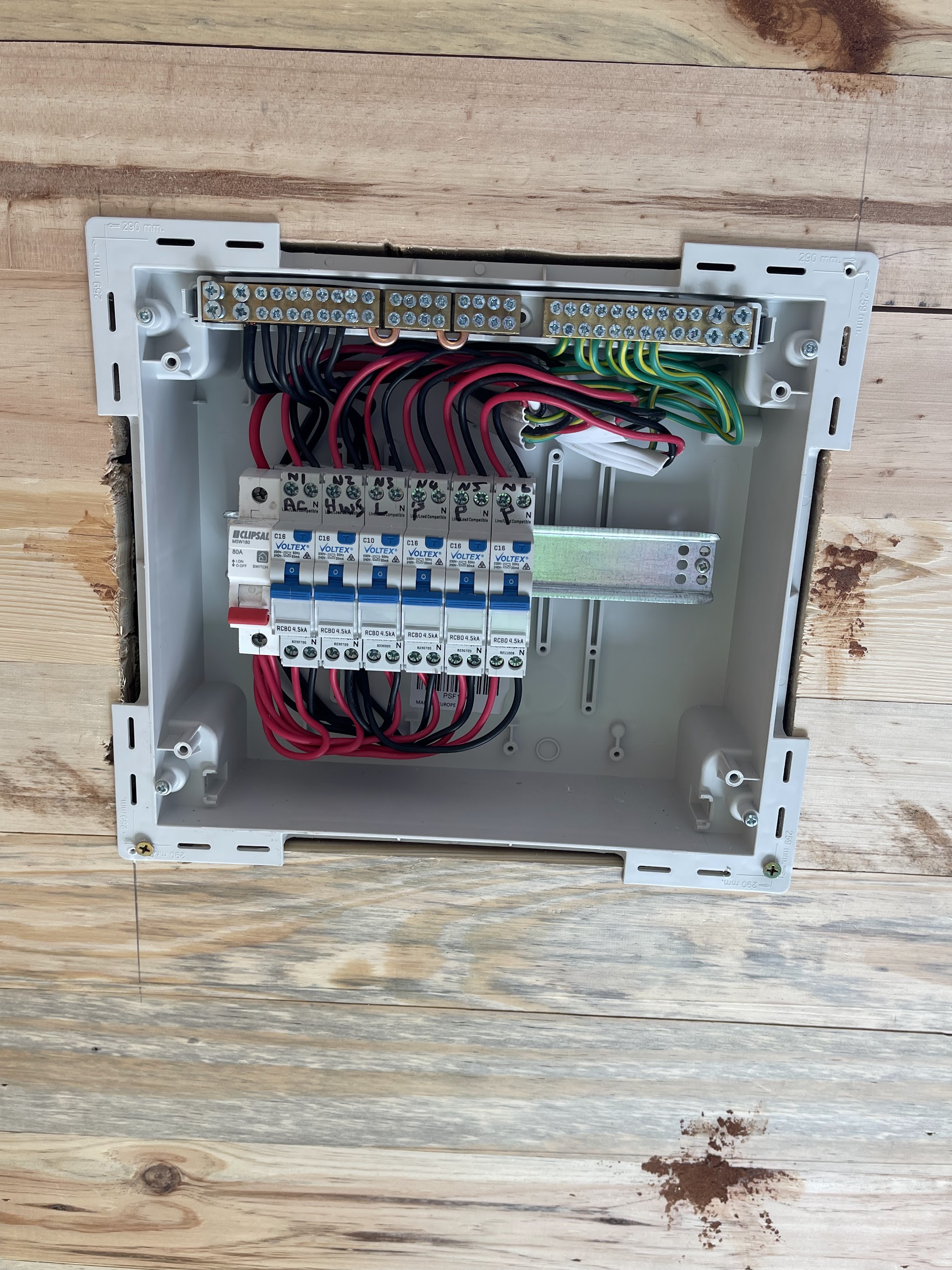 A brand new consumer unit with six RCBOs and colour coded wiring dressed square