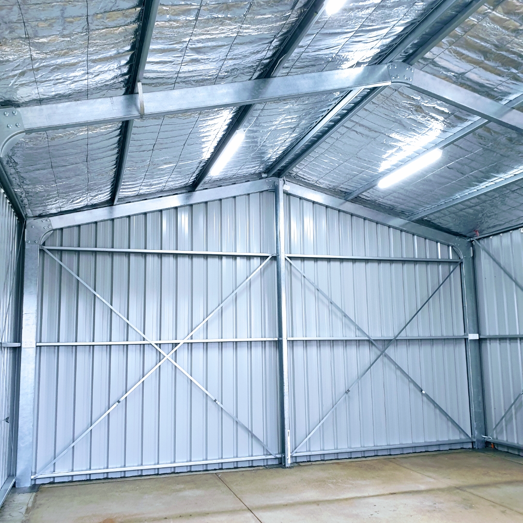 A large galvanised workshop shed lit by LED batten lights