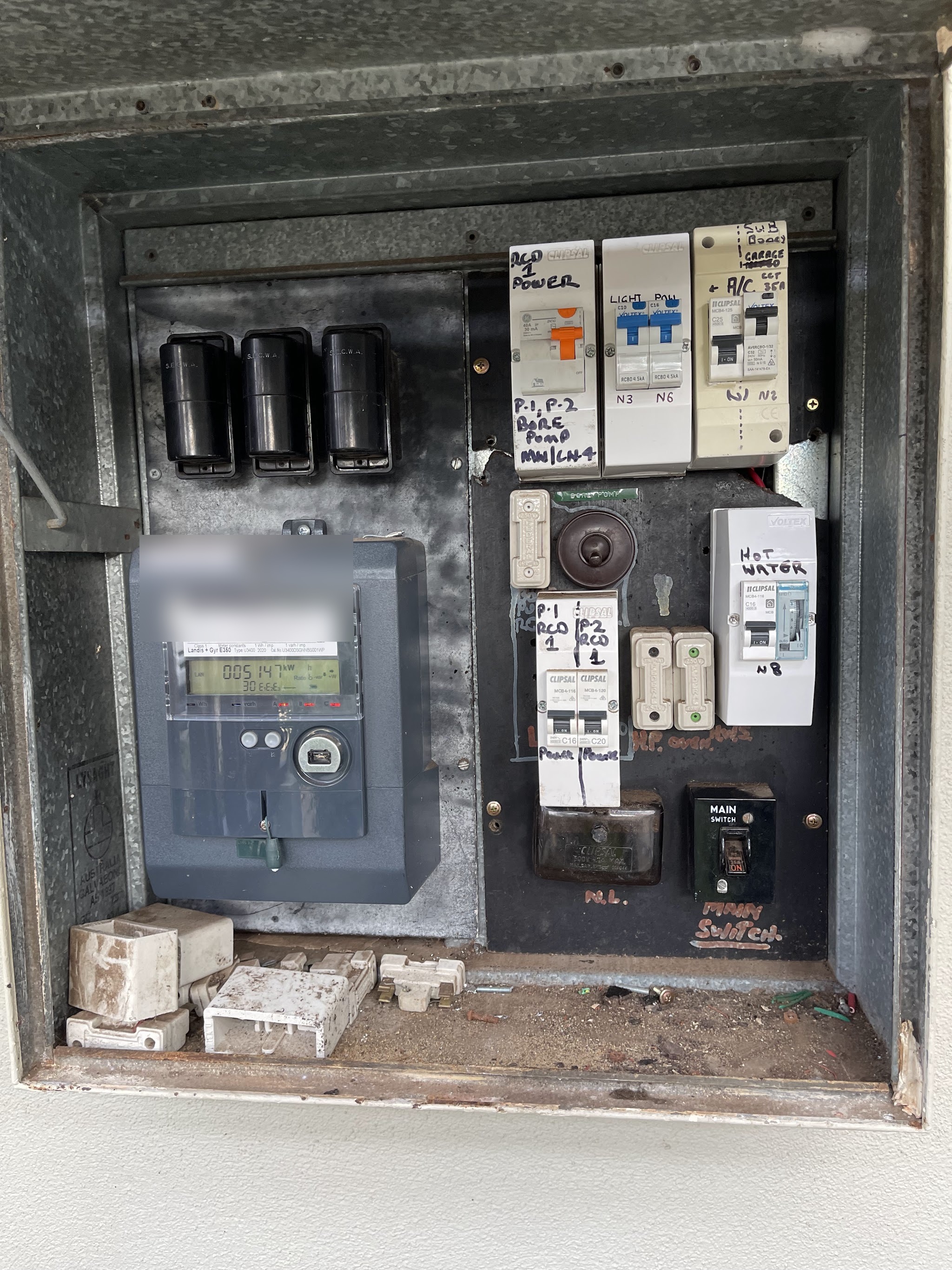 An old meter box with ceramic S.E.C.W.A. fuse carriers and safety switches added on over the years